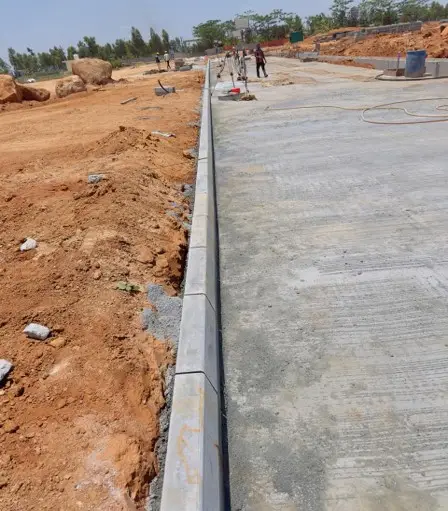 Main road kerb installation works in progress.