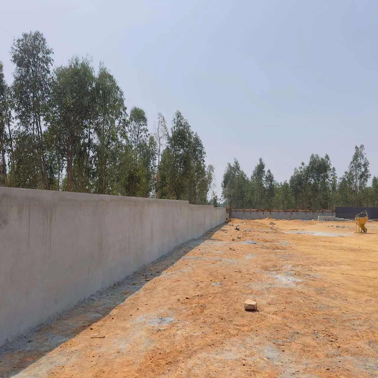 Compound wall beam concrete and plastering works in progress on south side.