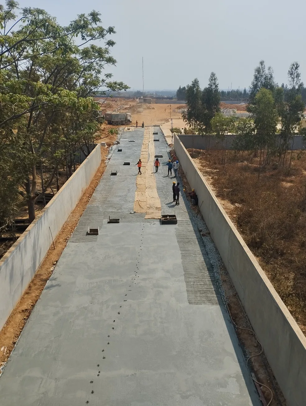 Entrance main road PCC works completed, curing works in progress and kerb laying works in progress.