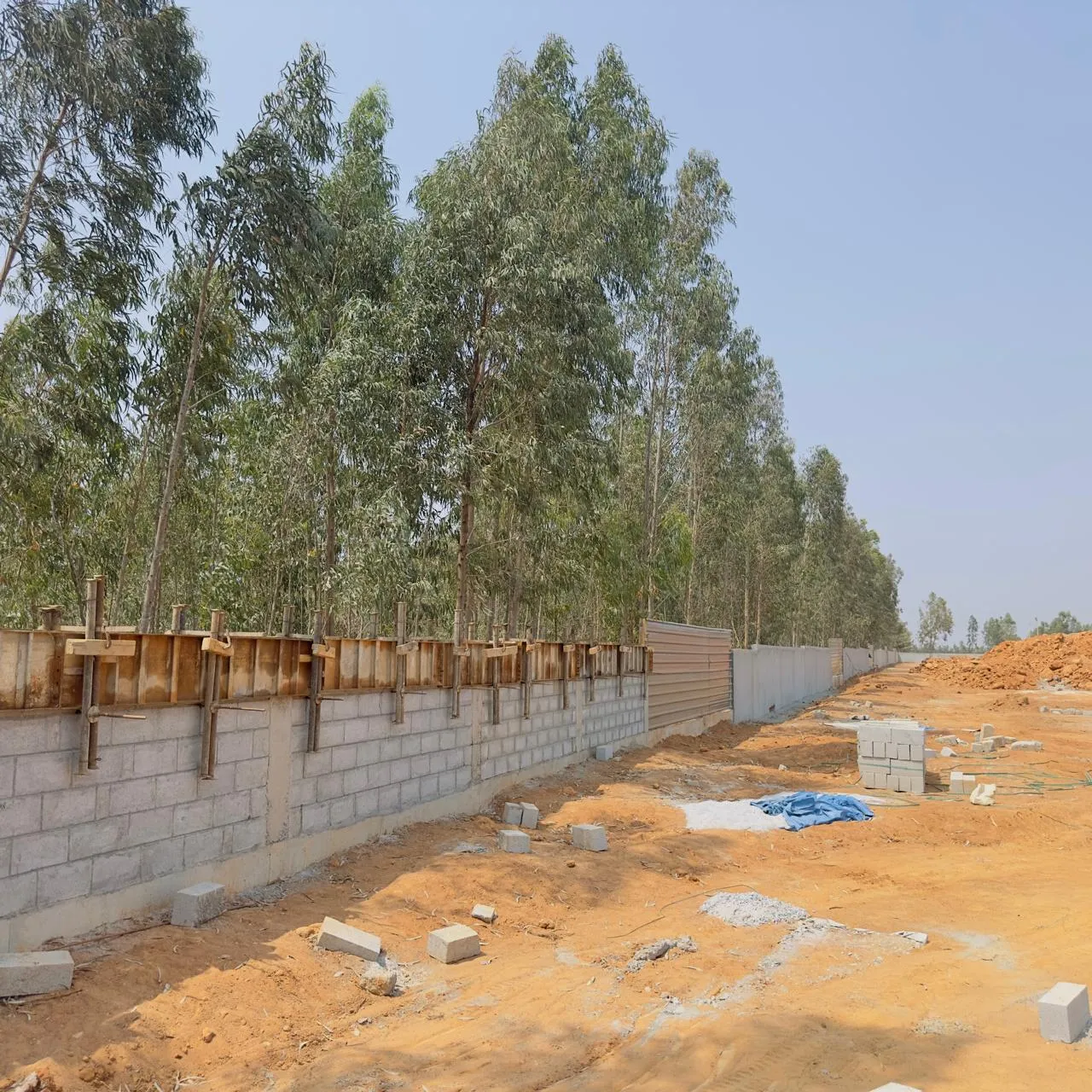 Compound wall beam concrete and plastering works in progress on south side.