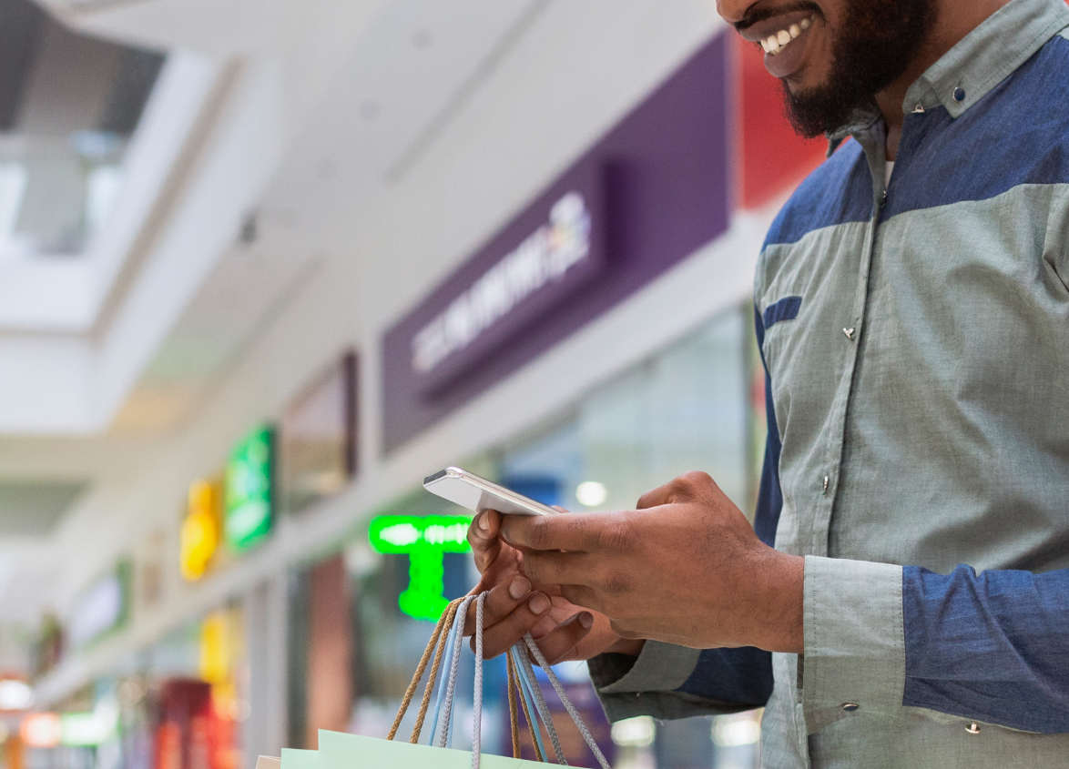Digital screens and brand kiosks inside a shopping mall promoting retail sales