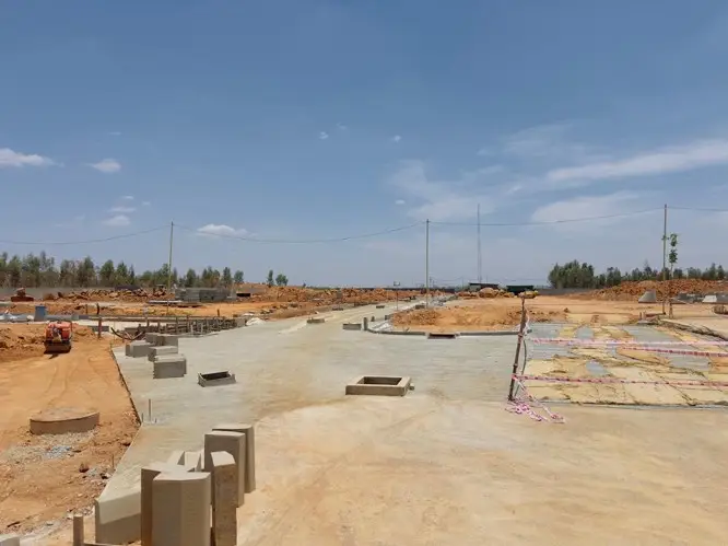 Main entrance spine road work completed and central park area levelling in progress.