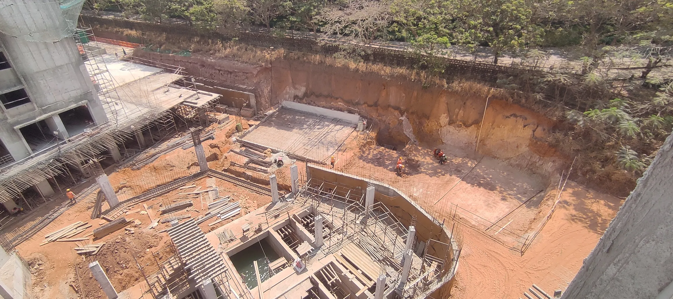 Excavation work completed. Retaining wall raft and PCC work is in progress.